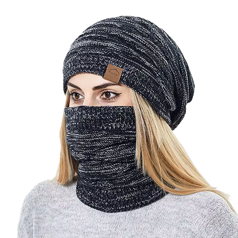 Femme portant un bonnet cagoule 2 en 1 gris foncé en tricot, couvrant entièrement la tête et le cou, sur fond noir pour accentuer le contraste.