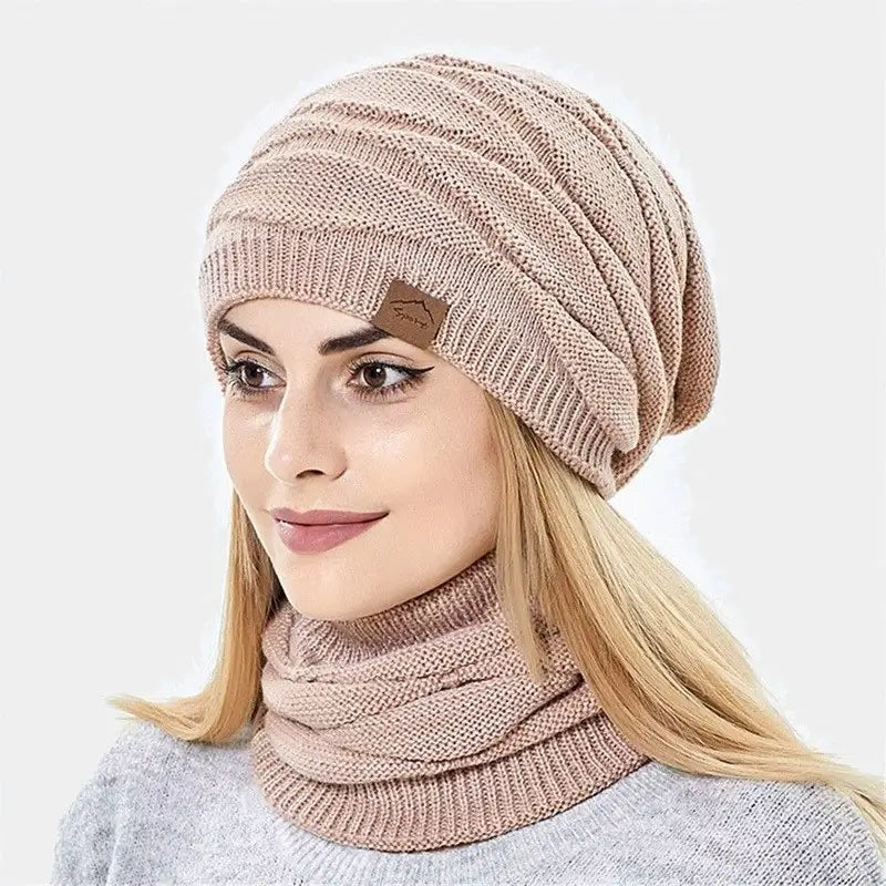 Femme portant un bonnet cagoule 2 en 1 rose, couvrant sa tête et son cou avec un design en tricot souple et élégant.