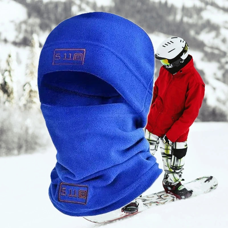 Bonnet cagoule bleu en polaire porté par un skieur dans un décor enneigé, conçu pour protéger efficacement contre le froid lors des activités hivernales comme le ski.