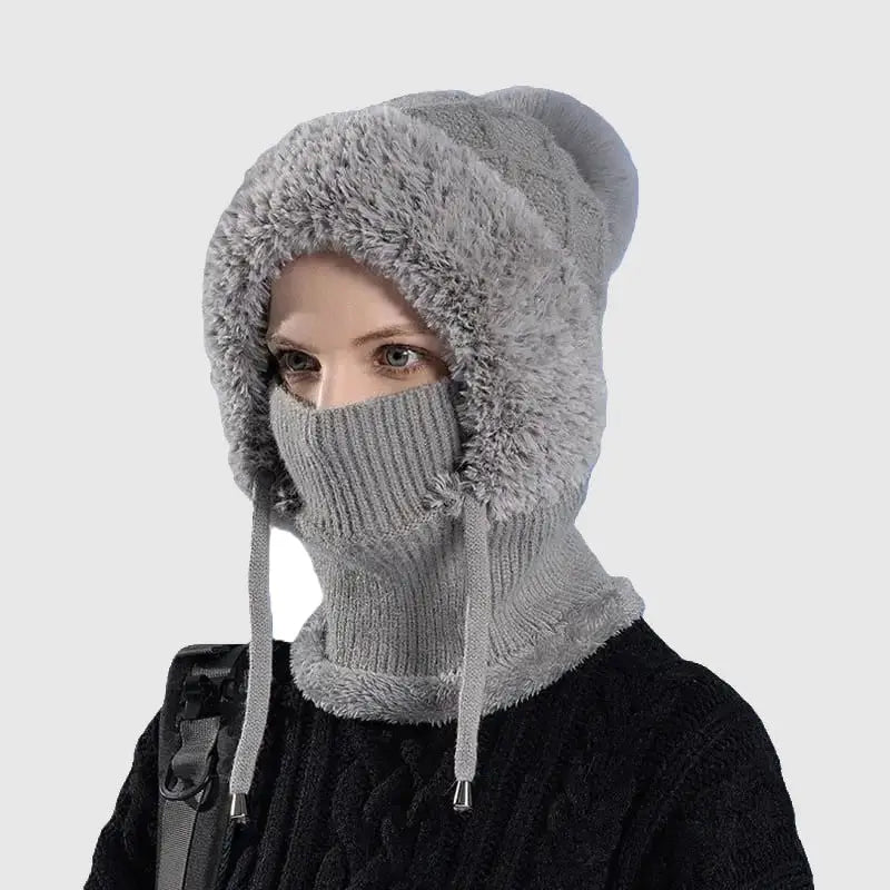 Femme portant un bonnet cagoule tricot gris avec une doublure douce et chaude, cordons ajustables et couverture intégrale pour le visage et le cou, idéal pour l'hiver et les activités en extérieur.