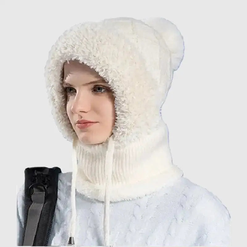 Femme vêtue d'un bonnet cagoule tricot blanc, doté d'une doublure en fausse fourrure douce et cordons ajustables, parfait pour protéger du froid en hiver ou lors d'activités outdoor.