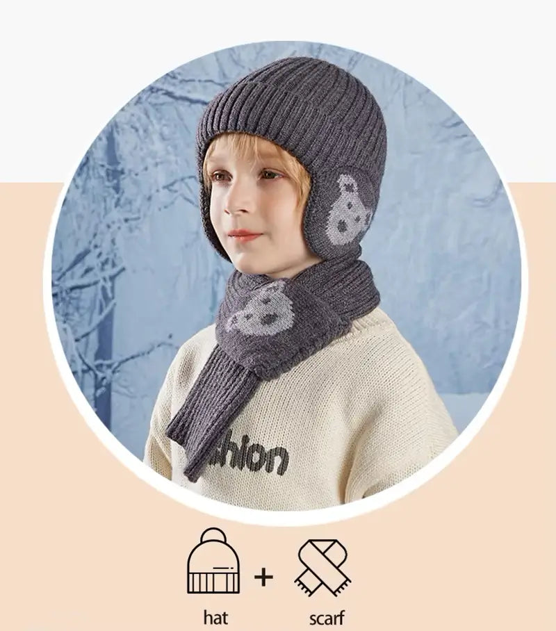 Garçon portant un ensemble bonnet écharpe enfant en tricot gris foncé avec des motifs d'ours, présenté dans un cadre circulaire avec un fond hivernal givré et des icônes indiquant l'association d'un bonnet et d'une écharpe.