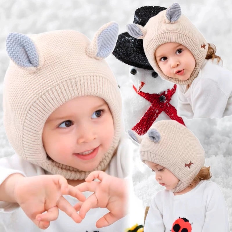 Deux enfants souriants portant une cagoule bébé 6 à 24 mois beige et grise avec des oreilles mignonnes, jouant dans un environnement enneigé. Parfait pour garder les tout-petits au chaud pendant l’hiver.