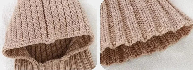 Gros plan sur les détails du tricot beige d'une cagoule bébé, mettant en valeur les finitions douces et confortables, idéales pour protéger la peau délicate des enfants.