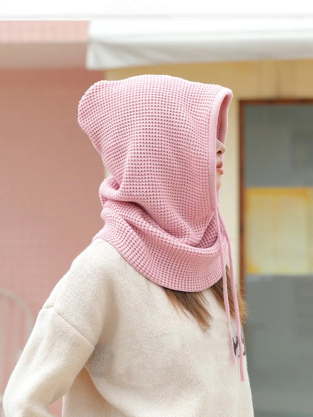 Vue arrière d’une femme portant une cagoule cache cou femme rose, capuche relevée pour une protection complète du cou et de la tête.