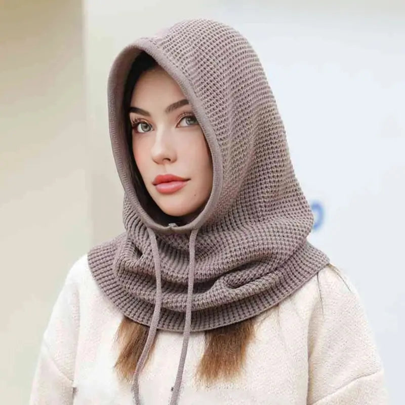 Femme souriante portant une cagoule cache cou femme, taupe, idéale pour se protéger du froid avec confort et élégance.