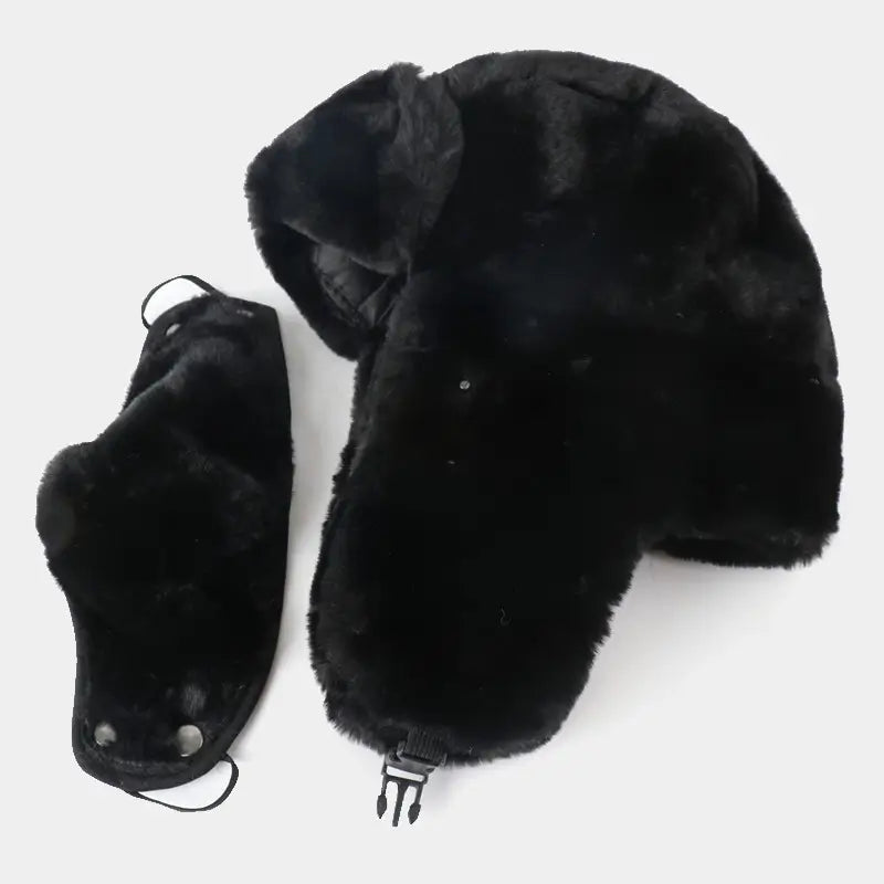 Cagoule Chapka noire avec mentonnière amovible, posée à plat aux côtés de la protection faciale détachable, illustrant la modularité et la praticité de ce modèle d'hiver.