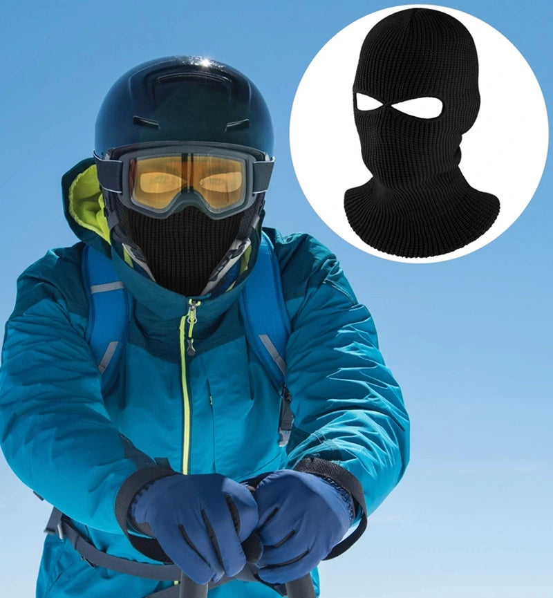 Cagoule Chouette noire portée sous un casque de ski, parfaite pour les sports extrêmes et la protection contre le froid glacial.