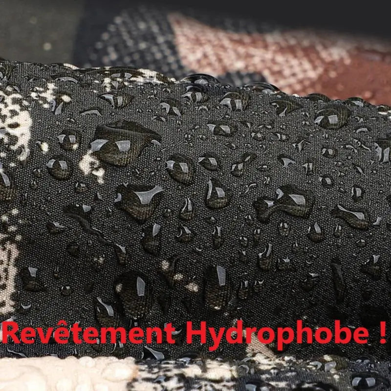 Zoom sur le revêtement hydrophobe d'une cagoule de chasse, montrant des gouttelettes d'eau perlant sur la surface imperméable. Idéal pour rester au sec lors des activités en extérieur dans des conditions humides.