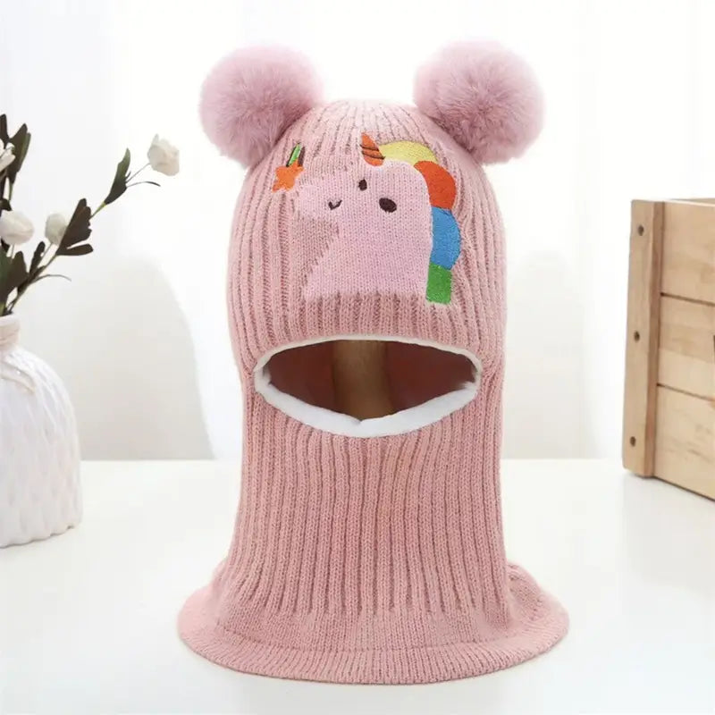 Cagoule enfant 4 ans rose pastel en tricot chaud, ornée de pompons et d'un motif licorne adorable.