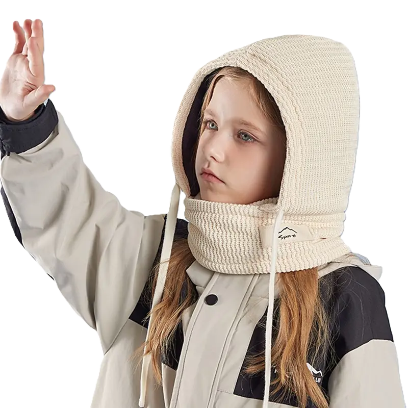 "Cagoule Enfant Hiver beige avec tour de cou, vue latérale portée par une fille. Parfaite pour les activités d’hiver comme le ski et le snowboard.