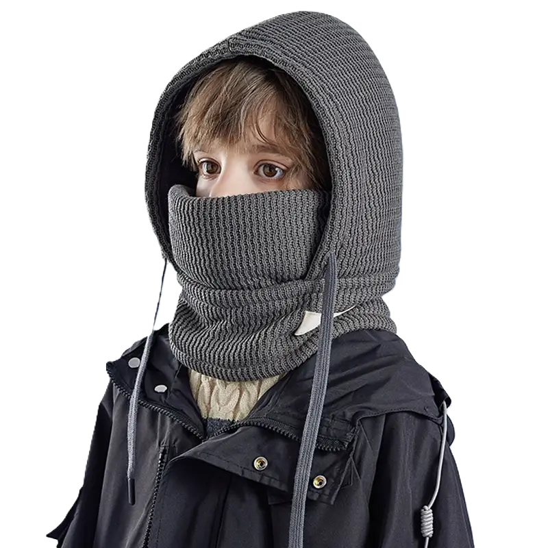 Cagoule Enfant Hiver noire avec tour de cou, portée par un garçon. Tricot épais et doublure chaude, idéal pour les sorties en montagne ou les journées froides.