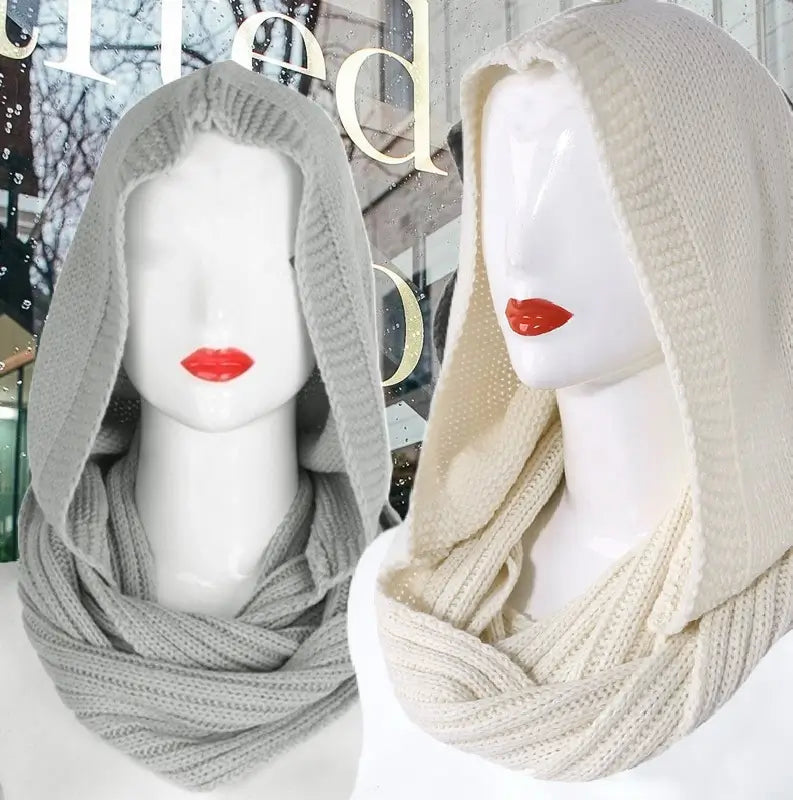 Deux mannequins exposant des cagoules femme en tricot moderne, l'une en gris clair et l'autre en beige, avec capuche ample et écharpe intégrée, parfaites pour les tendances de mode hivernale