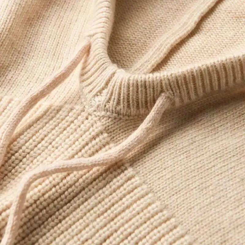 Gros plan sur la texture en maille beige d'une cagoule hiver femme, montrant la douceur du tissu et la finition soignée des coutures.