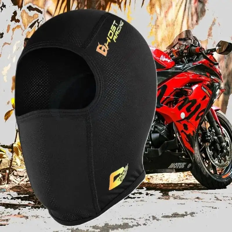 Cagoule Moto en Soie noire ultra-légère avec ouverture faciale, posée devant une moto rouge sur un fond urbain. Conception respirante et ajustée pour une protection optimale sous le casque.