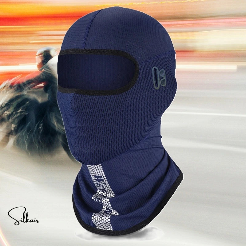 Vue dynamique d’un motard filant sur la route avec la Cagoule Moto été SilkAir en bleu marine. La cagoule recouvre entièrement la tête et le cou, avec une ouverture pour les yeux et un protège-cou allongé, idéale pour la conduite estivale.