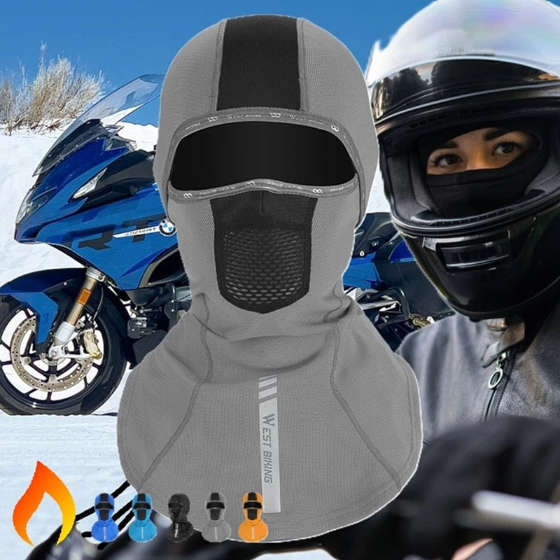 Cagoule Moto pour femme à cheveux longs en gris, conçue pour protéger du vent et du froid, portée avec un casque moto sur un arrière-plan de paysage enneigé.