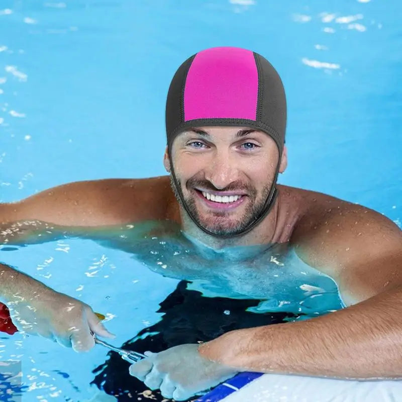 Homme souriant en piscine, équipé d'une cagoule néoprène de natation ou plongée en eau froide rose et noire, idéale pour protéger du froid et améliorer l'aérodynamisme.