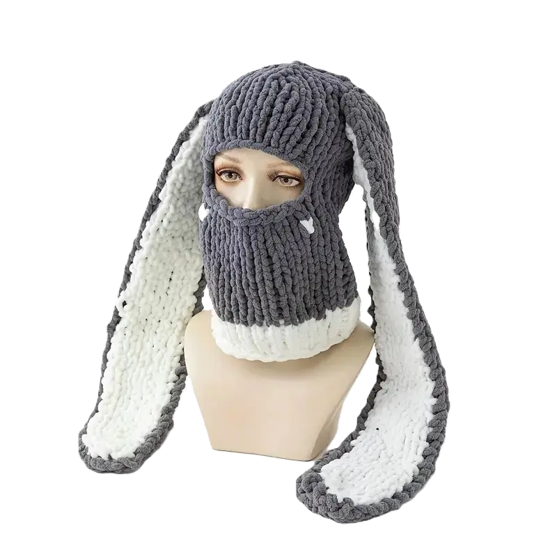 Cagoule Oreilles de lapin grise et blanche sur mannequin – Une cagoule chaude en laine gris foncé avec des oreilles de lapin doublées de polaire blanche est exposée sur un mannequin, sur un fond noir contrasté.