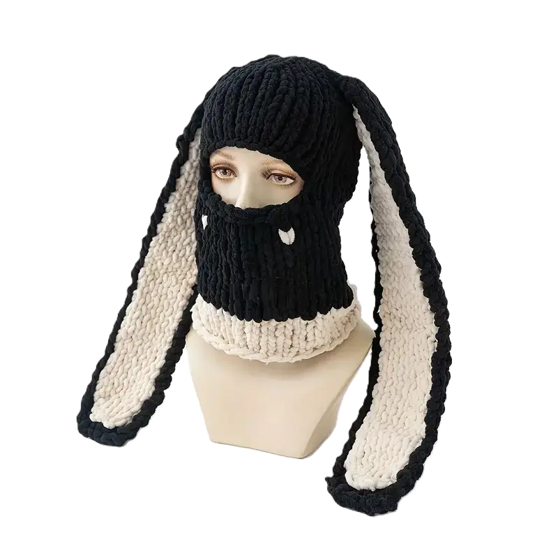 Cagoule Oreilles de lapin noire et blanche sur mannequin – Un mannequin présente une cagoule en tricot noir avec des oreilles de lapin longues et souples doublées de blanc. Idéale pour le froid et les sports d’hiver.