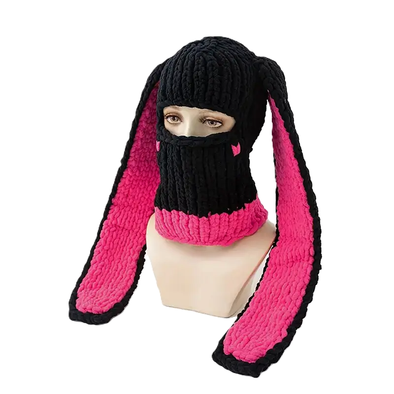 Cagoule Oreilles de lapin noire et rose sur mannequin – Une cagoule de ski noire avec des oreilles de lapin doublées de rose vif est posée sur un mannequin, parfaite pour un look original et tendance.