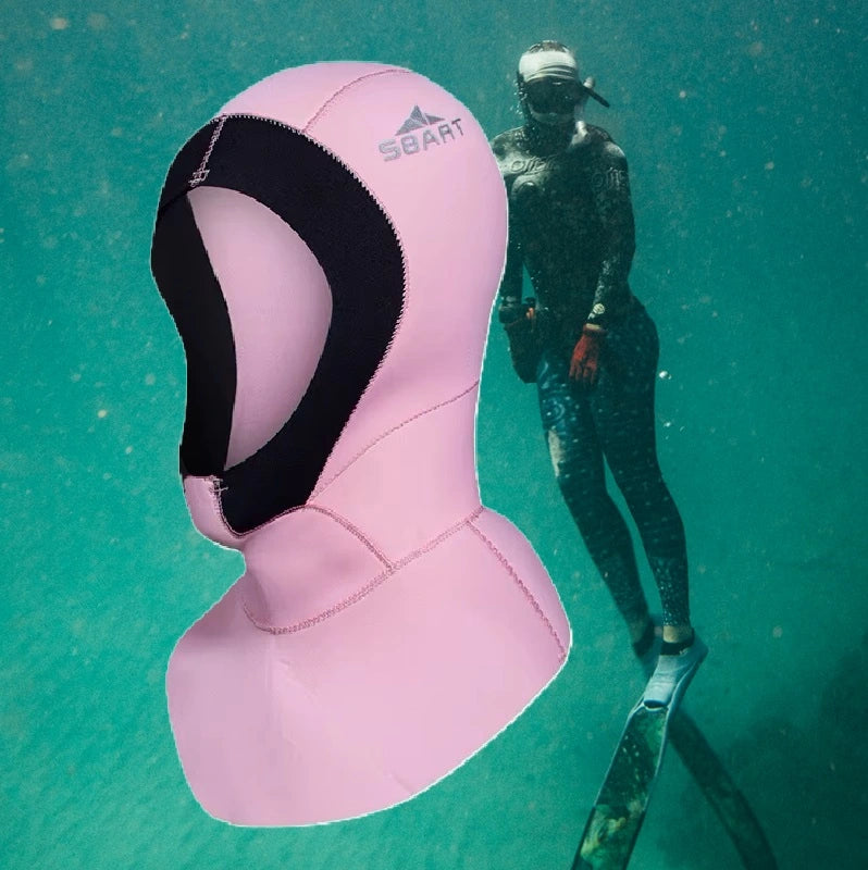 Femme plongeant sous l'eau avec une cagoule de plongée femme couleur rose, offrant une protection thermique dans un environnement aquatique.