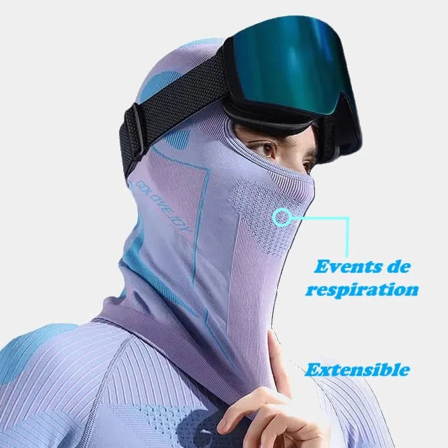 Cagoule ski femme bleue portée avec un casque de ski, extensible et respirante pour activités hivernales.