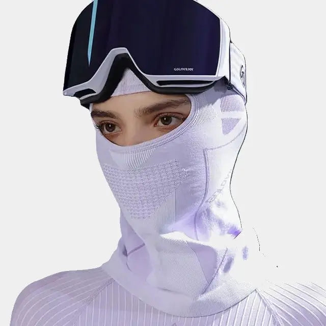 Femme portant une Cagoule Ski Femme violine, adaptée au ski avec évents de respiration et compatible avec un masque de ski