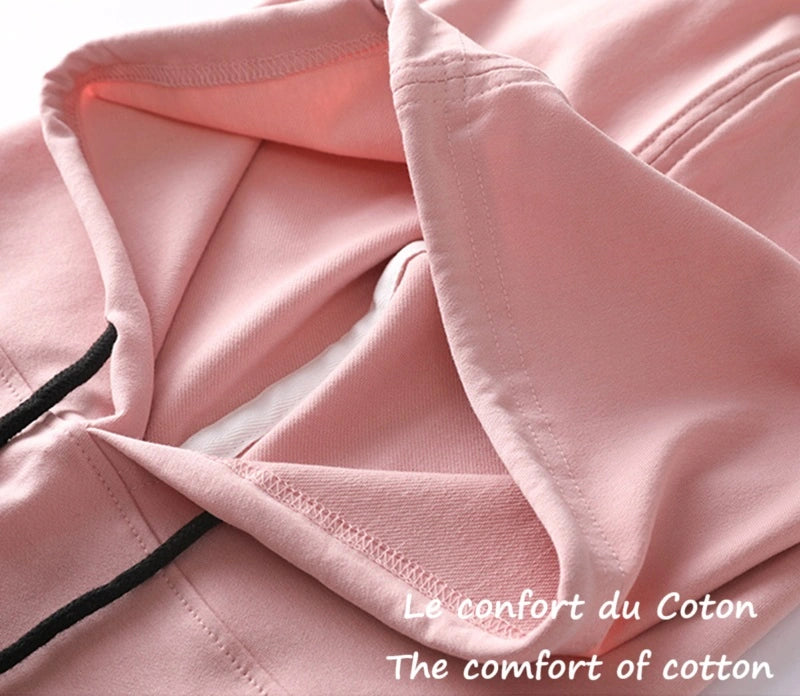 Gros plan sur le tissu doux d'une Cagoule streetwear rose. Texture souple et agréable pour un confort optimal en hiver.