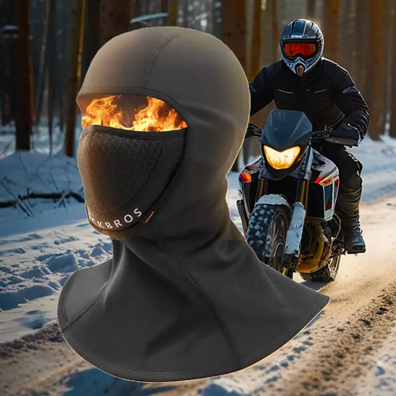 "Cagoule thermique moto noire avec protection intégrale pour le visage, conçue pour les conditions hivernales extrêmes, portée par un motard dans une forêt enneigée. Idéal pour protéger du froid et du vent pendant les trajets à moto.