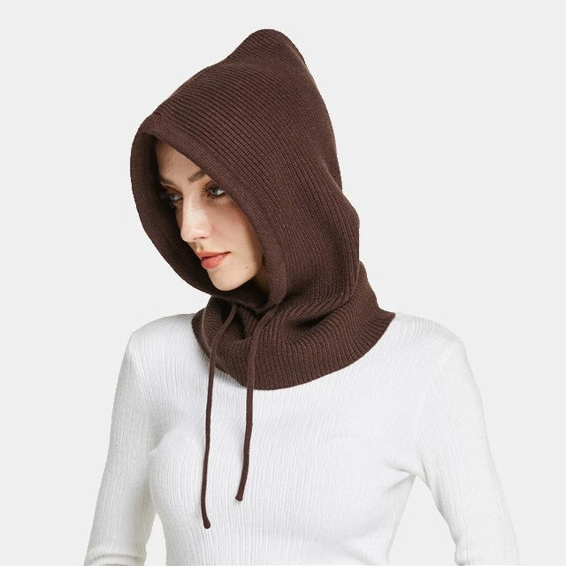 Femme portant une cagoule tricot coffee en maille douce avec capuche ajustable, parfaite pour se protéger du froid avec élégance.