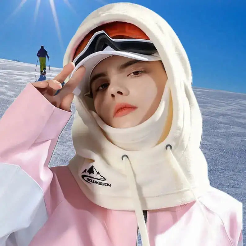 Capuche cagoule pour femme en beige, portée par une femme avec un casque de ski, adaptée aux activités d'extérieur et au froid hivernal.