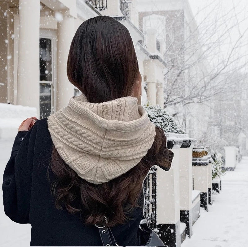 Vue arrière d'une femme portant une capuche cagoule tricot beige avec une finition torsadée, parfaite pour l'hiver en ville