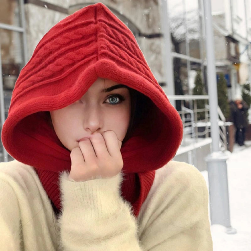 Capuche cagoule tricot rouge pour femme, élégante et chaude, portée dans un environnement hivernal enneigé.