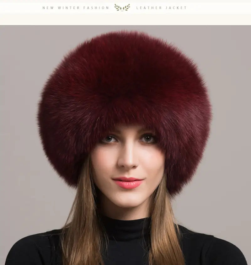 Femme élégante portant une Chapka Russe en vraie fourrure bordeaux, au design luxueux et volumineux. Un accessoire d’hiver raffiné, idéal pour affronter le froid avec élégance et distinction.