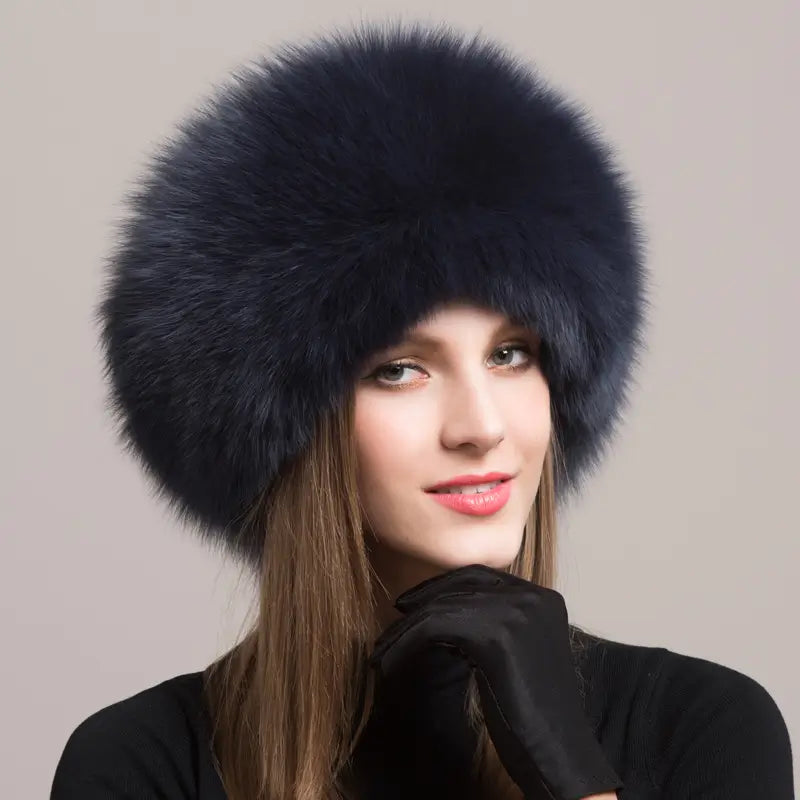 Femme élégante portant une Chapka Russe en vraie fourrure bleu foncé, avec une finition volumineuse et raffinée. Un accessoire d’hiver luxueux, idéal pour affronter le froid avec style.