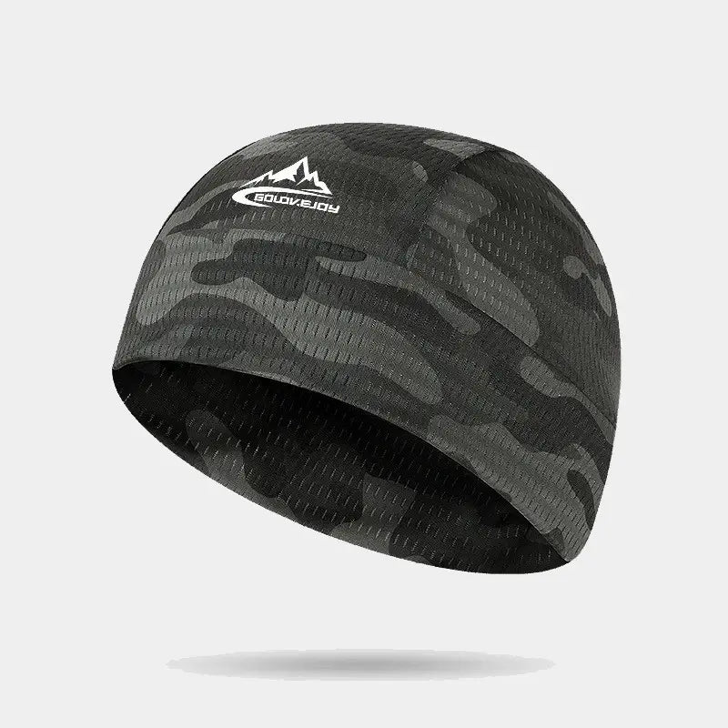 Sous casque été camouflage noir et vert, offrant une protection respirante et ajustée pour les activités extérieures.