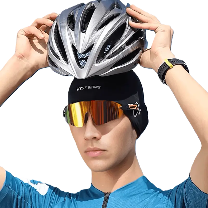 Cycliste portant un sous casque vélo été noir avec des lunettes de sport miroir, ajustant son casque de vélo gris. Accessoire respirant et léger, idéal pour l’été, assurant confort et absorption de la transpiration sous un casque.